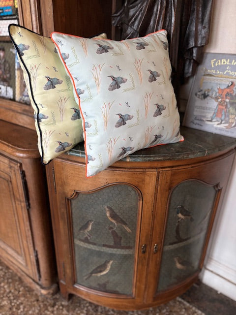 Coussin vert d'eau à passepoil orange fluo