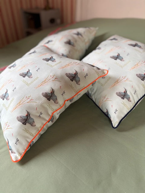 Coussin vert d'eau à passepoil orange fluo